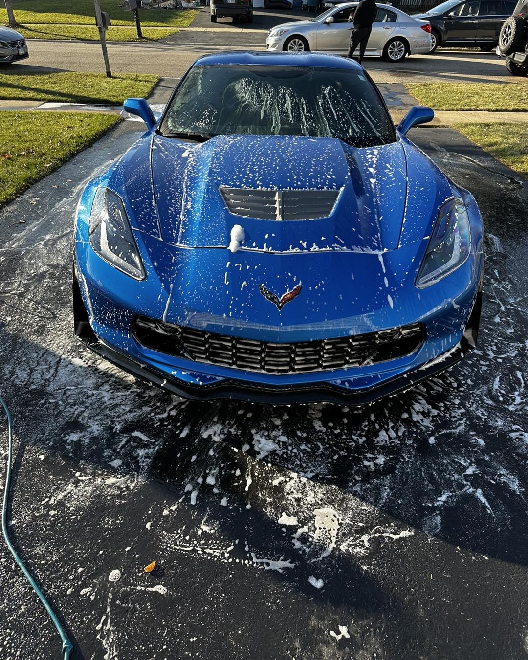 Blue Corvette getting a mobile foam wash at a customer's home