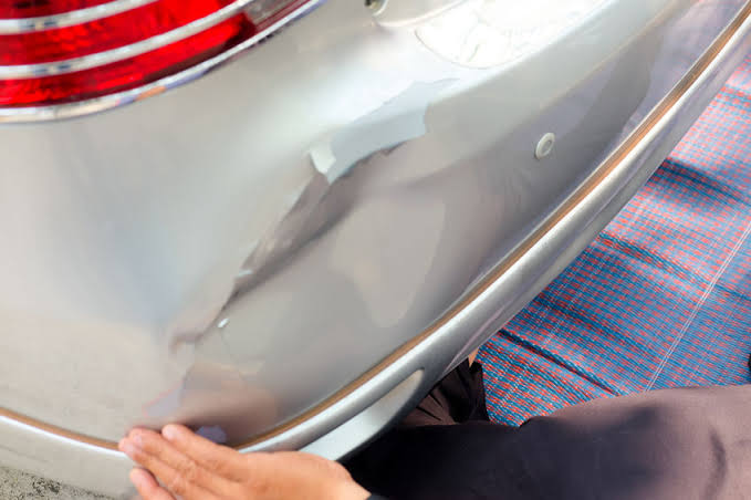 Minor dent and crease on a rear bumper before paintless dent repair at Detail Tech