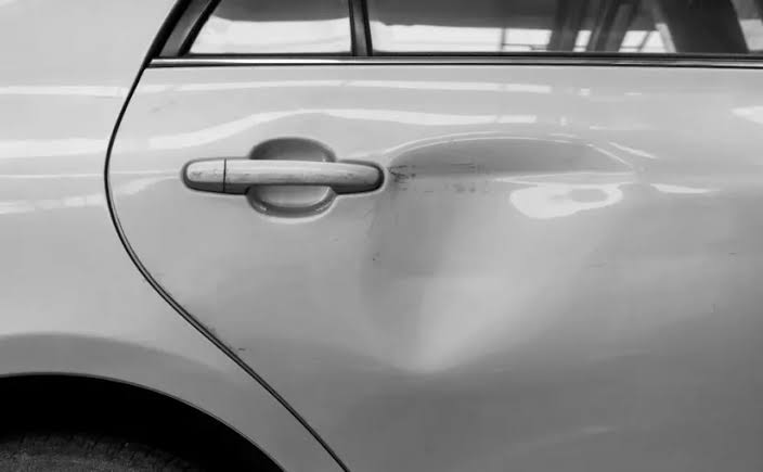 Door ding on a car panel before paintless dent repair at Detail Tech