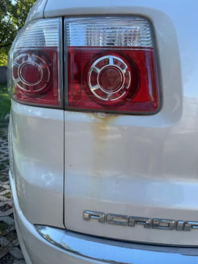 Vehicle rear quarter panel before iron decontamination, showing rust staining