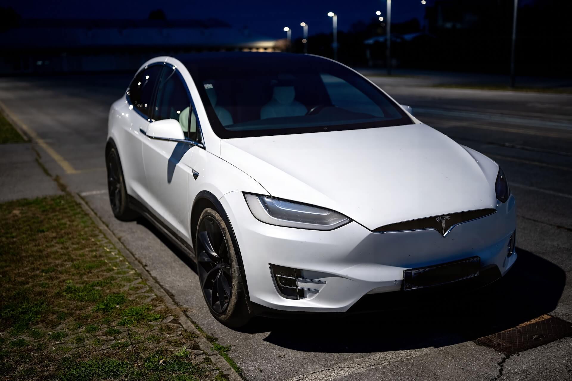 Front quarter of a white Tesla with protective film