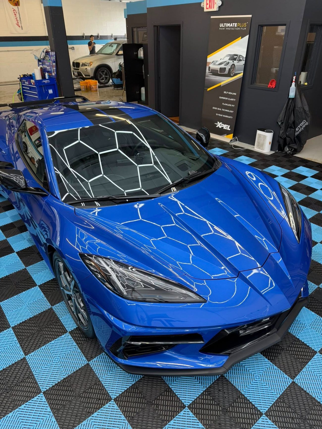 Vinyl wrap film being applied to a vehicle panel at Detail Tech