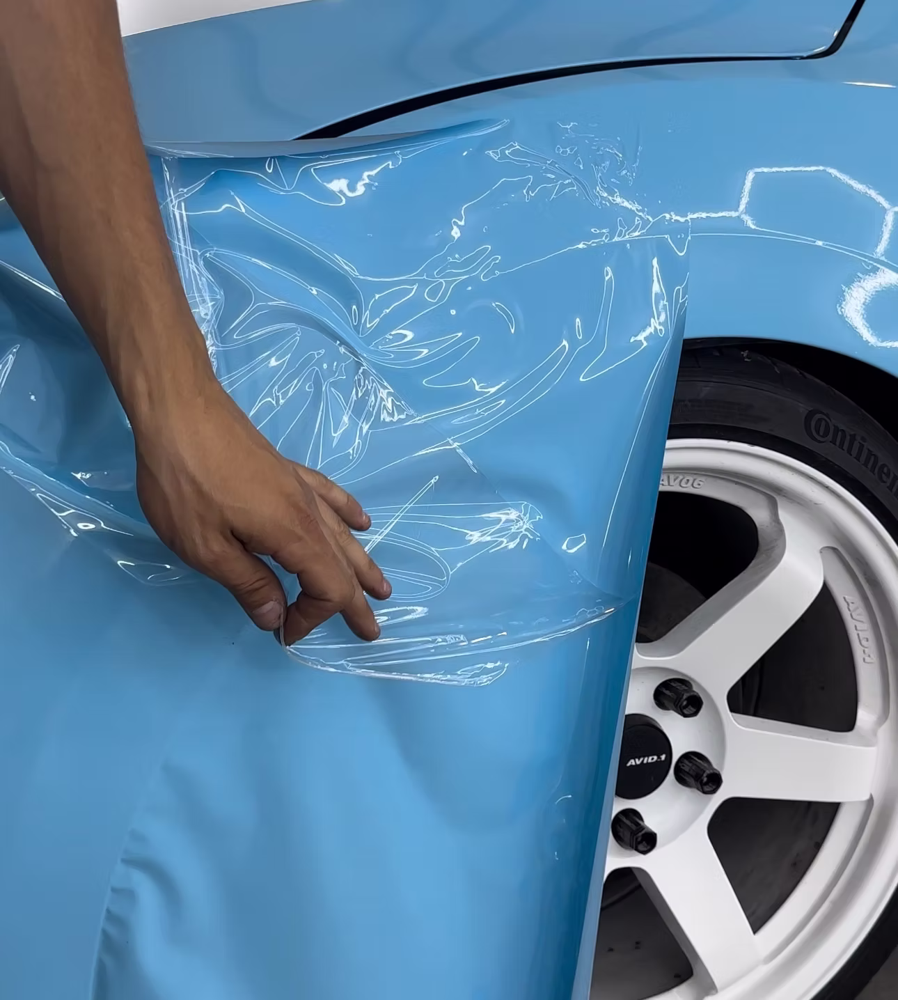 Blue color-change vinyl wrap being installed on a sports car at Detail Tech
