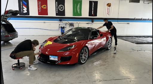 Detail Tech team working on a red sports car