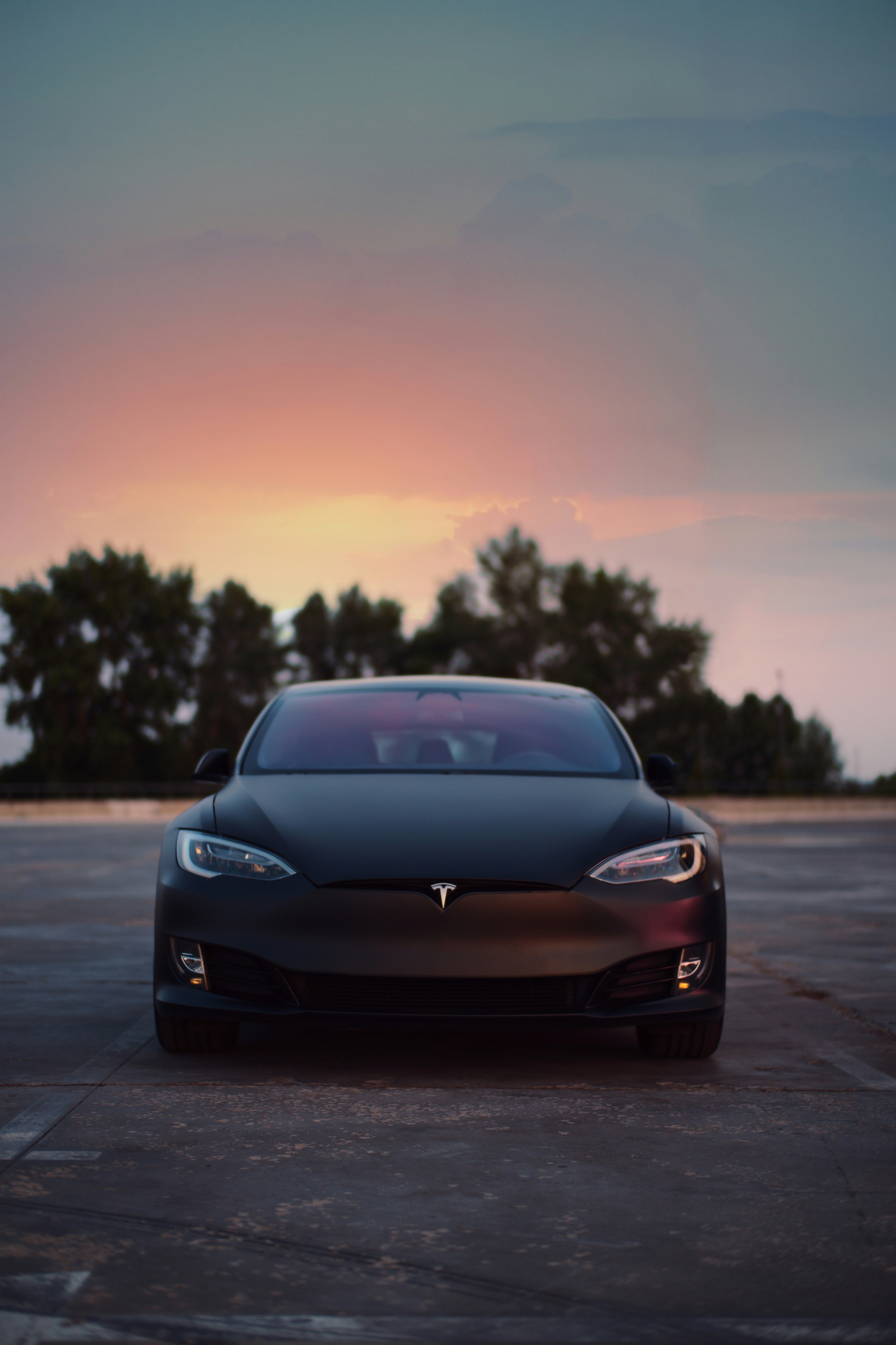 Matte black Tesla with tinted windows at dusk